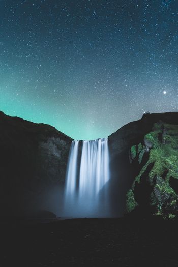 SCENIC VIEW OF WATERFALL AGAINST STAR FIELD AGAINST SKY