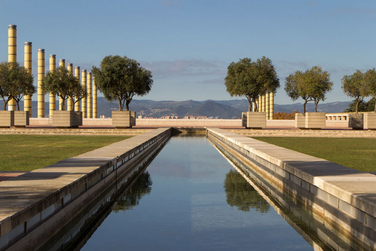 Swimming pool by lake against sky