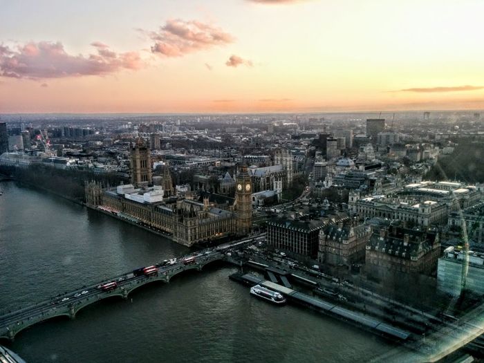 Aerial view of westminster bridge over river by buildings against sky at dusk in city