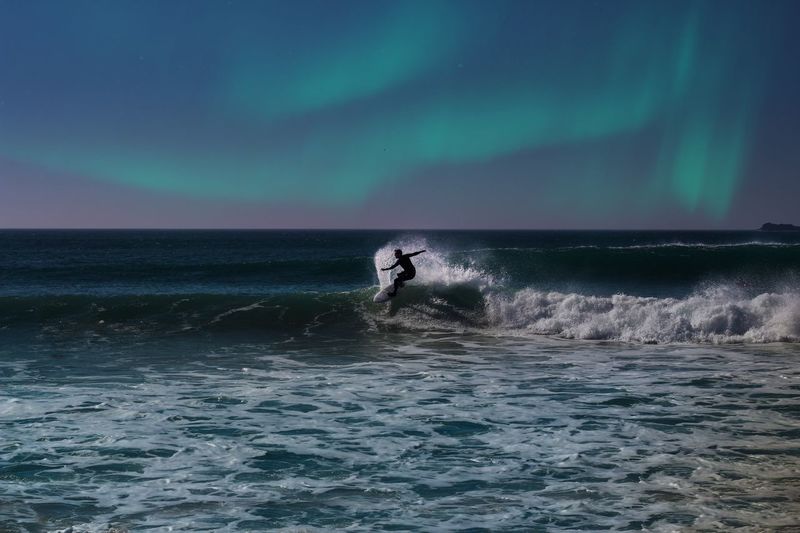 Man surfing in sea against sky