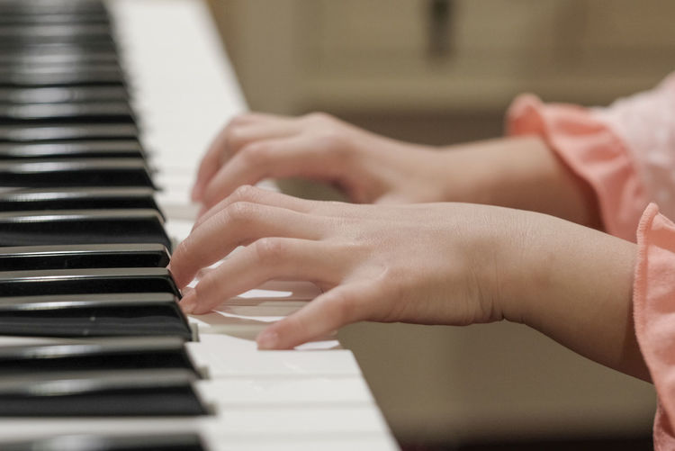 Midsection of hands playing piano