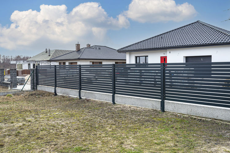 Modern anthracite panel fencing, visible spans and a fence foundation connector, view from garden