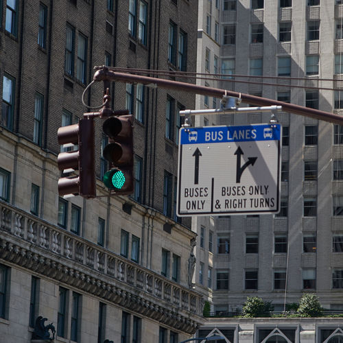 Low angle view of road signal against buildings