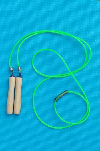 High angle view of green jump rope on blue table