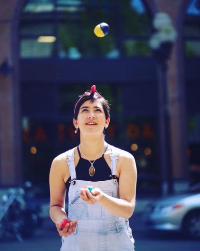 View of young woman juggling outdoors