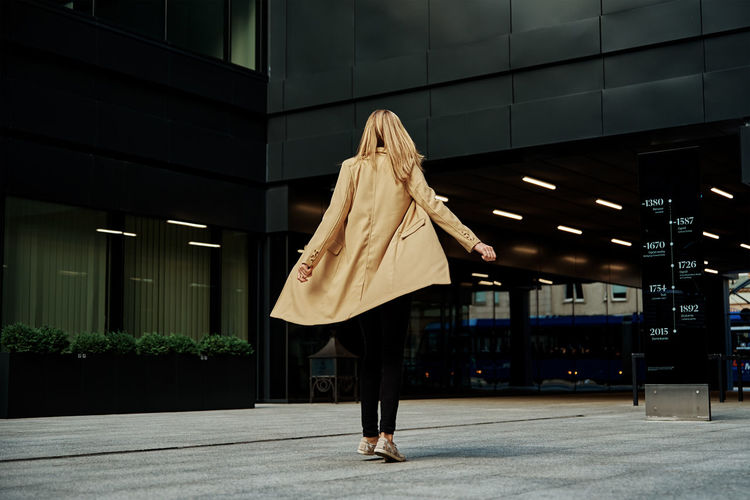 Woman in coat walks at city stret