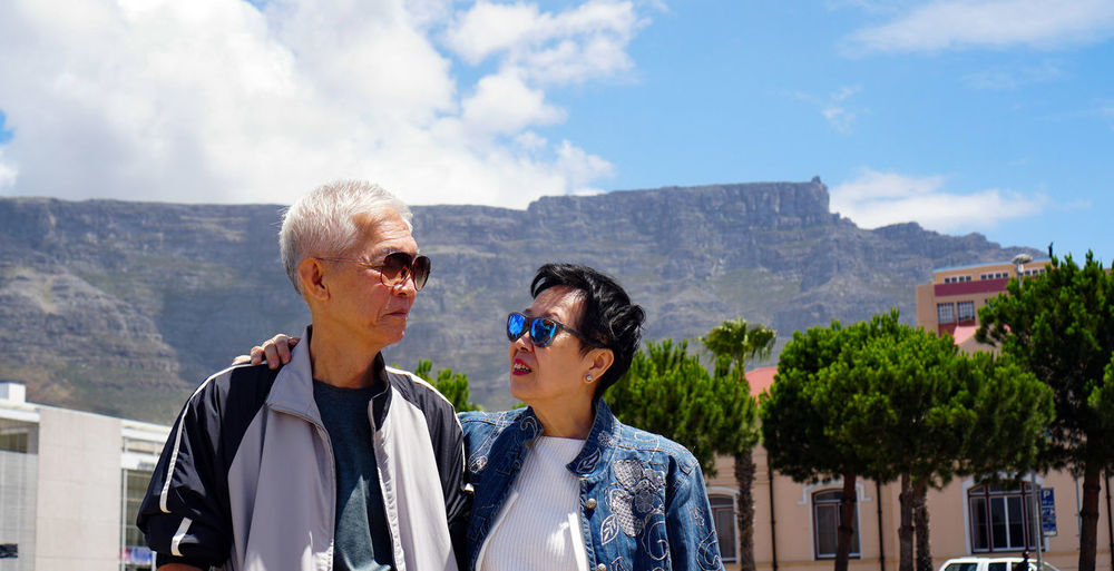 Smiling senior couple standing against mountain