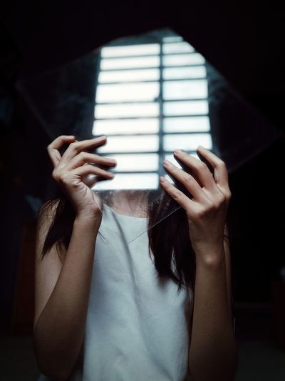 Midsection of woman covering face with hands