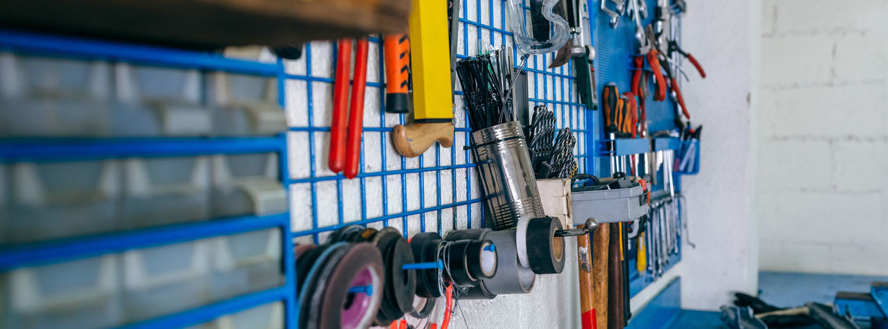 Close-up of various work tools hanging in workshop