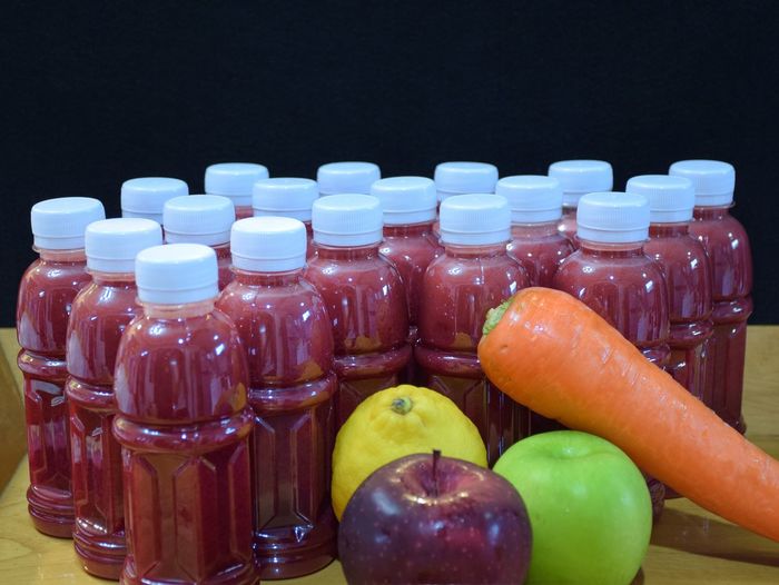 Close-up of fruits and vegetables with juice on table