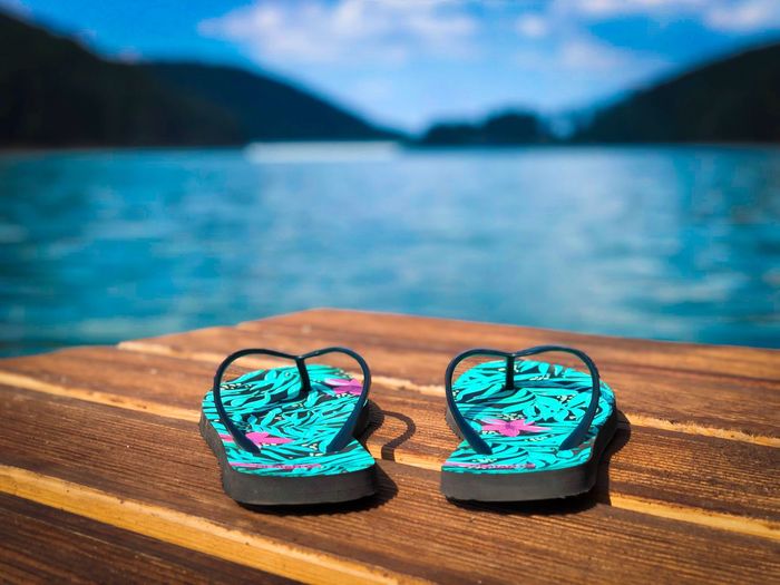Flip flops on wooden pontoon near the lake
