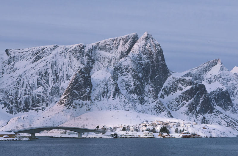 Scenic view of snowcapped mountains by sea against sky