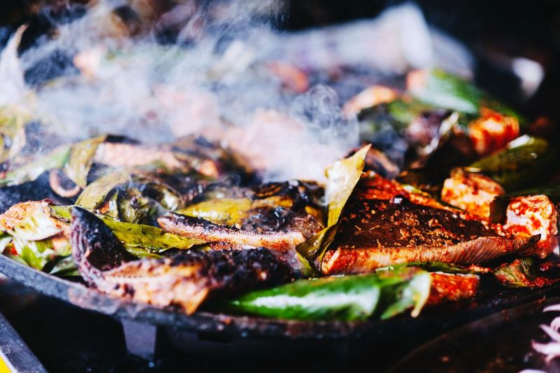 Sting ray fish being cooked in banana leaves
