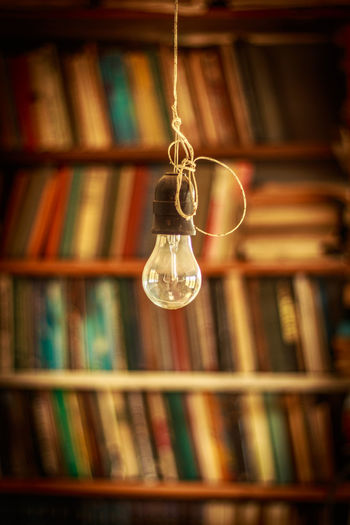 Close-up of electric bulb hanging at home