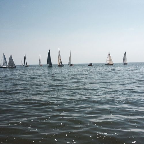 Sailboats in sea against clear sky