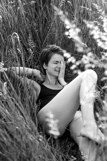 Laughing woman lying on grass monochrome scenic photography