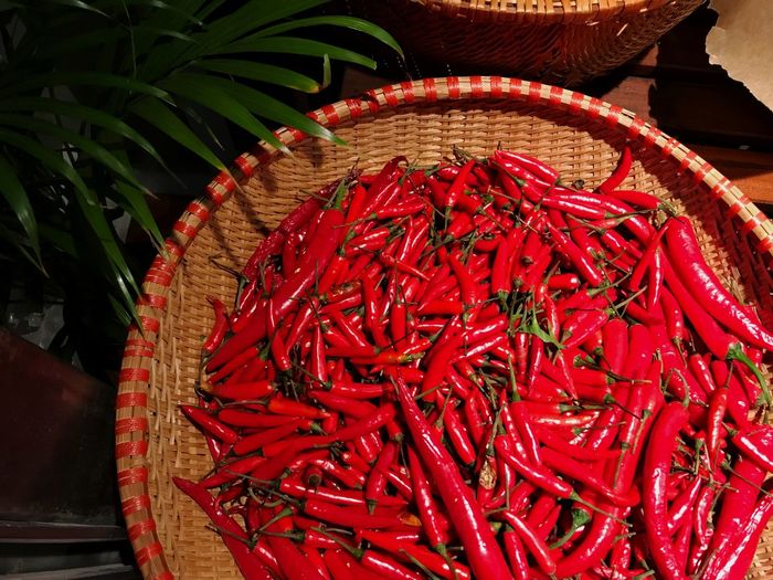High angle view of red chili peppers in basket at market