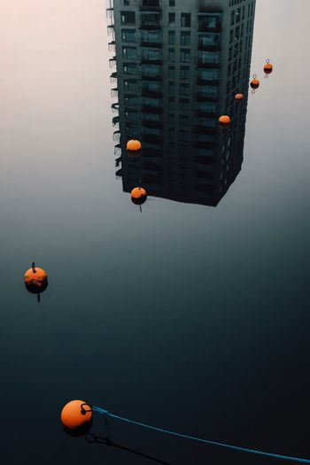 LOW ANGLE VIEW OF BALLOONS FLYING AGAINST BUILDINGS IN CITY