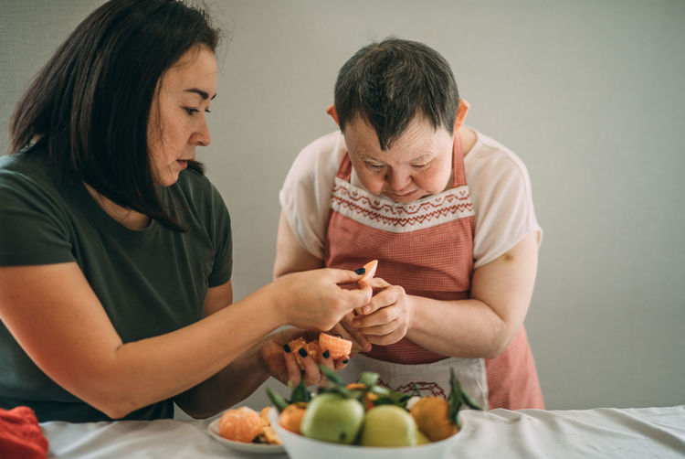 Lifestyle, education, elderly woman with down syndrome is studying in kitchen, classroom teacher
