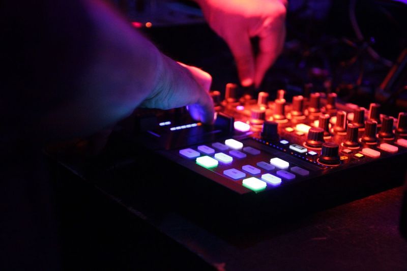 Close-up of dj adjusting knobs on sound mixer