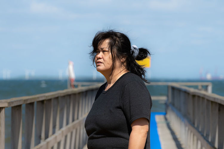 An asian middle aged woman on a jetty 