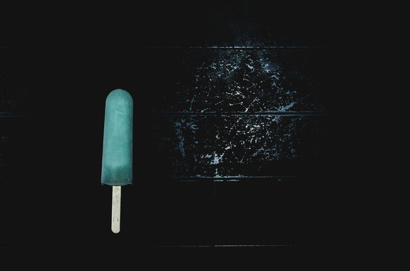 Close-up of popsicle against black background