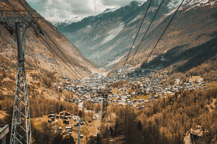 Ski lifts against mountains in town