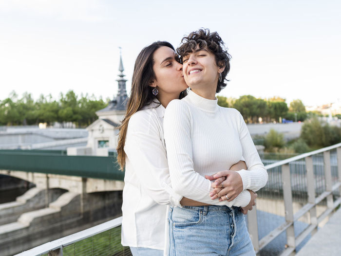 Romantic woman kissing and hugging lesbian friend