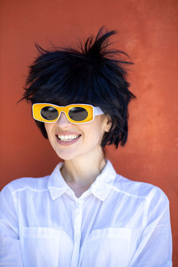 Young woman with wig and yellow sunglasses