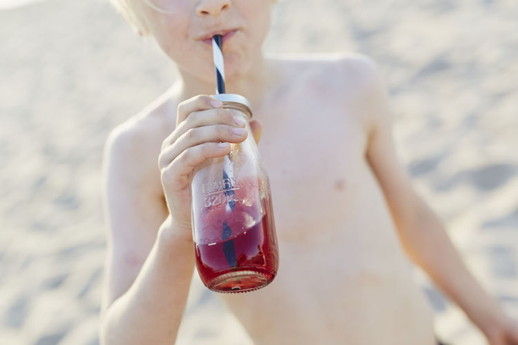 Boy having drink on beach