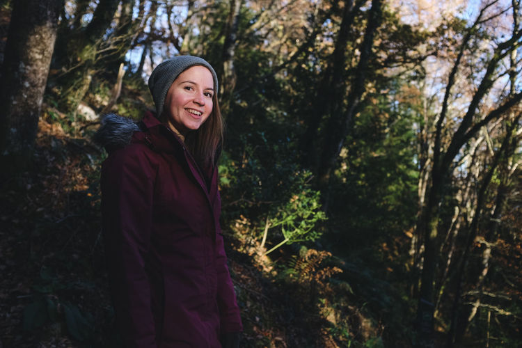 Portrait of smiling woman against trees