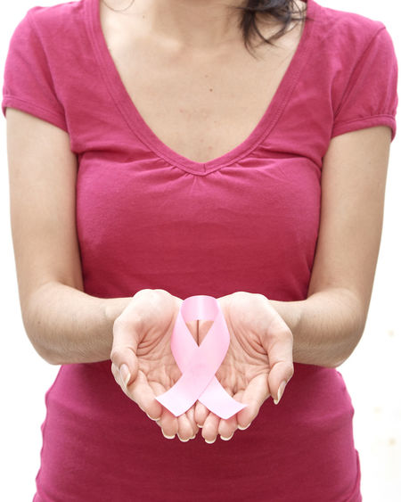 Woman holding pink breast cancer awareness ribbon against white background