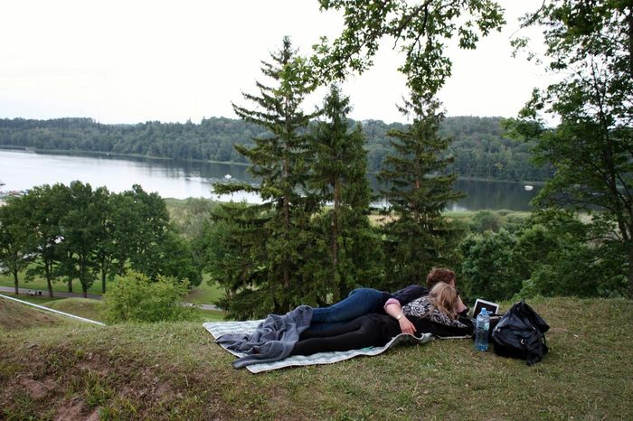 Couple relaxing on hill by trees