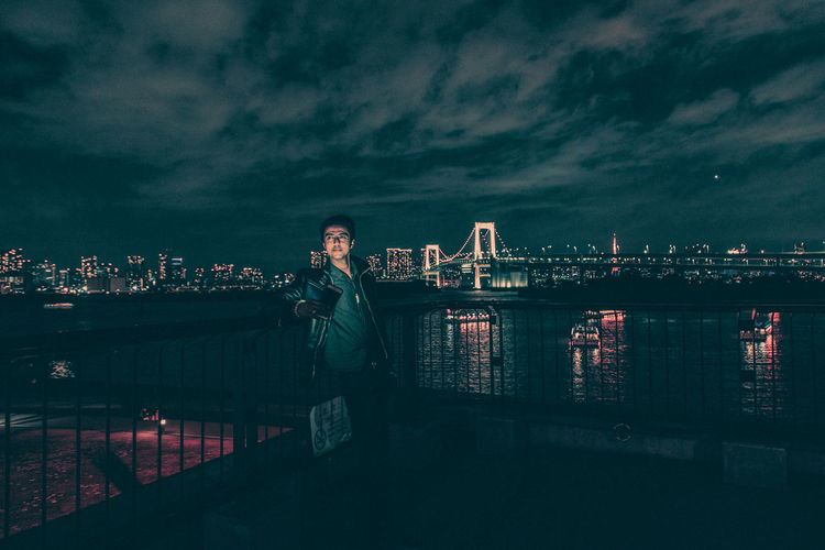 Man taking selfie while standing against sky at night