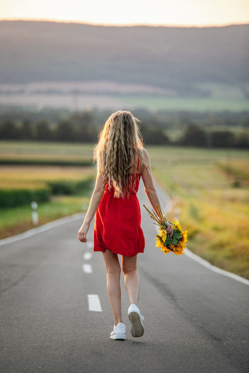 Rear view of woman walking on road
