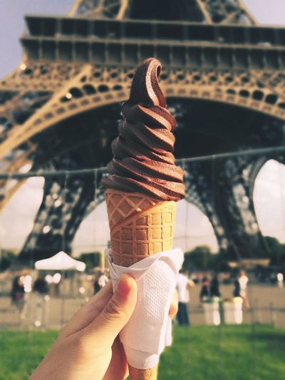 Close-up of woman holding ice cream cone near eiffel tower
