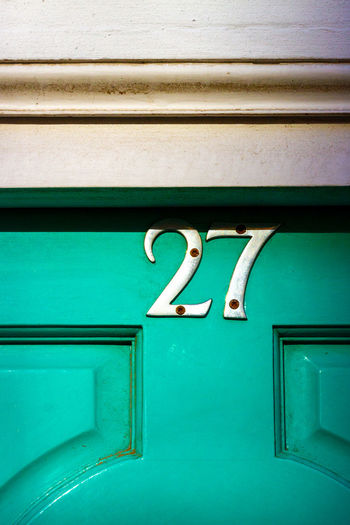 House number 27 on a wooden front door 