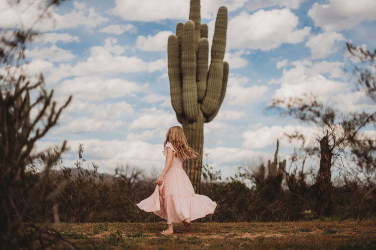 Girl twirling in desert with cactus