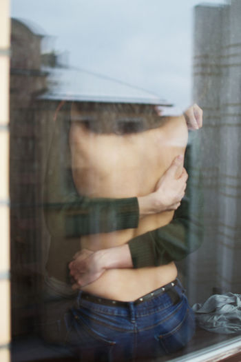Midsection of woman holding glass window