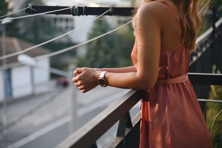 Midsection of woman standing at railing
