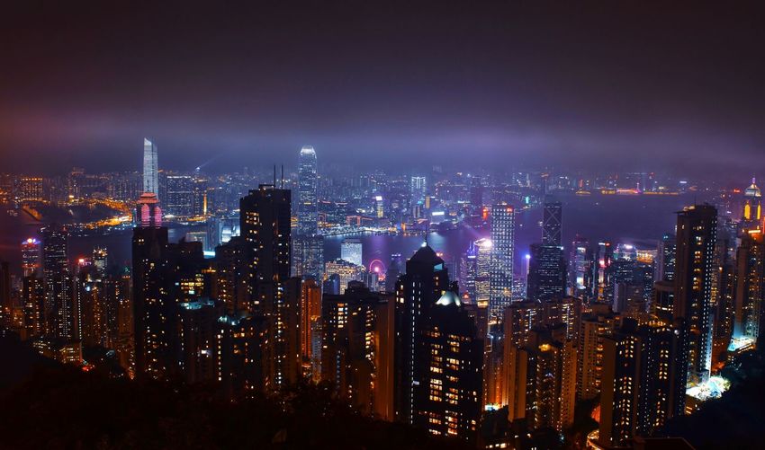 High angle view of illuminated buildings against sky at night