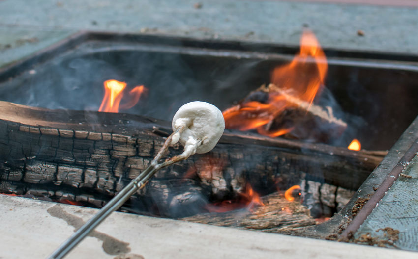 Roasting marshmallows over a camp fire outdoors on a crisp autumn night