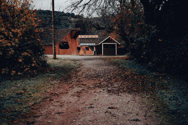 Rustic dirt road with historic shell gas station in fall
