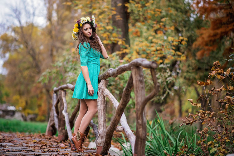 Full length portrait of young woman in autumn leaves