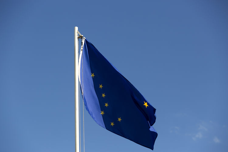 Low angle view of european union flag waving against clear blue sky
