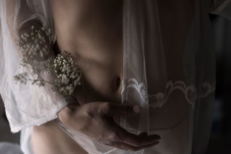 Midsection of woman holding curtain