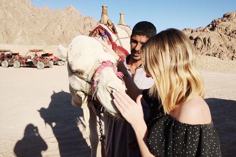 Close-up of woman with camel at desert