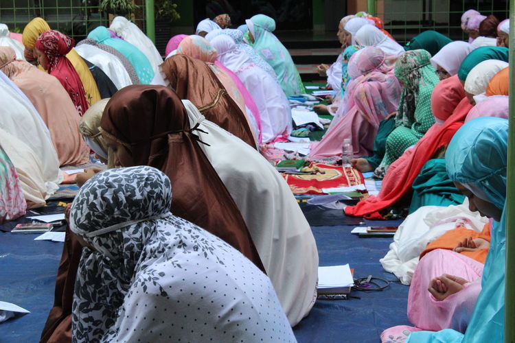 Women wearing hijab praying at mosque