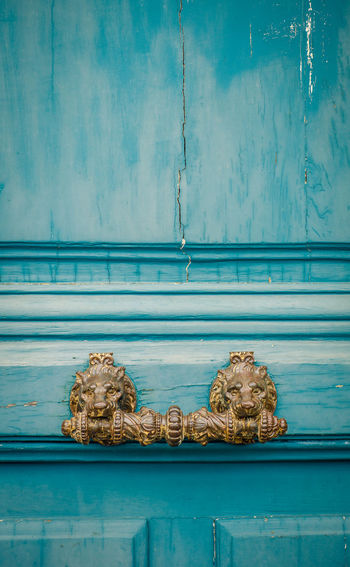 Ornate lion handle on a rustic door in paris, france