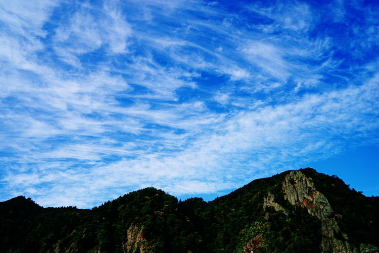 High section of mountain range against blue sky